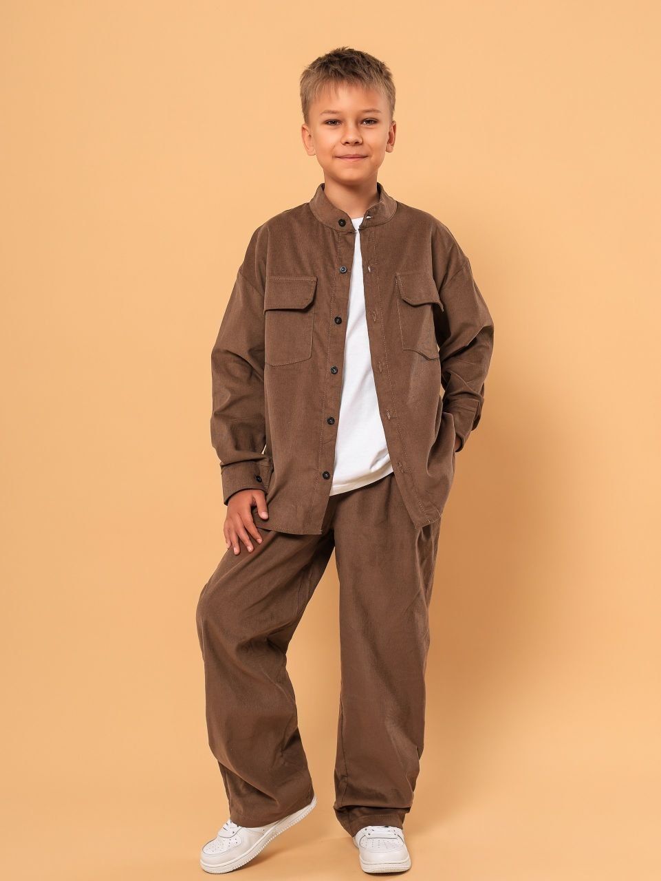 Boy in a brown corduroy shirt and wide trousers