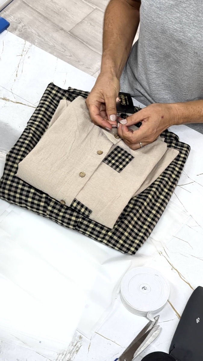 Hands buttoning a folded corduroy shirt