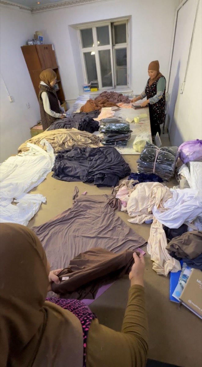 Two women sorting garments and packing them into bags